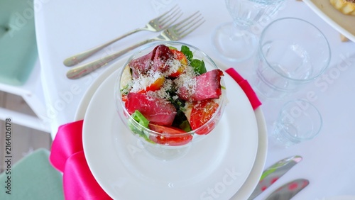 Foto Roasted beef slices layered with ripe tomatoes, peppery arugula, and shredded ch
