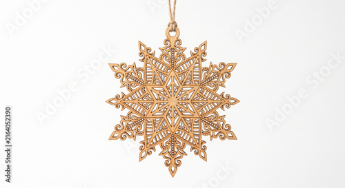Intricate wooden snowflake ornament with detailed laser cut design hanging on a string against a clean white background