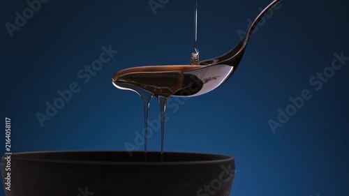 Golden Honey Dripping from Silver Spoon into Ceramic Bowl Slow Motion Video