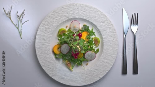 Healthy fresh organic fruit and vegetable salad served on white plate top view