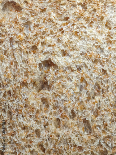 Rustic Whole Wheat Bread Crumb Texture Close Up. Detailed macro photograph showing the airy crumb structure, bran flecks, and soft porous surface of artisan whole wheat bread.