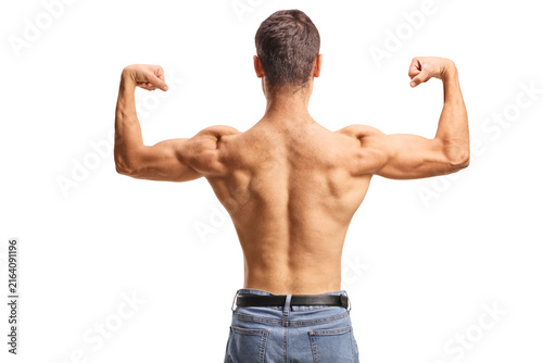 Rear view shot of a muscular man in jeans flexing his back and biceps