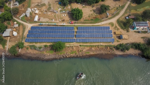 Aerial View of Sirajganj Power Station with Solar Panel Rows Along Riverbank and Small Boat in Bangladesh