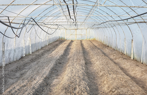 The interior of a greenhouse with soil prepared for planting.