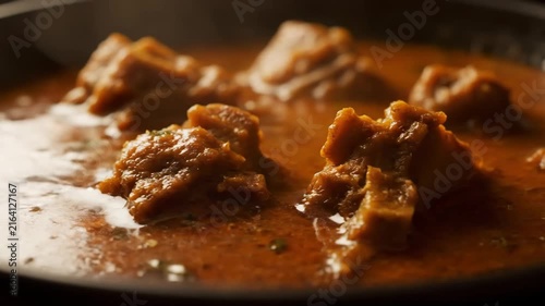 Close-up Macro Shot of Rich and Spicy Indian Meat Curry Simmering in a Pot. Traditional South Asian Mutton or Beef Dish (Gosht or Rogan Josh).