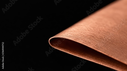 Thin Etched Copper Foil Rolled Edge Macro on Black Background