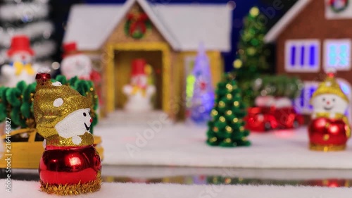 A yellow car quickly drives up to a snowman against a blurred background of a Christmas village