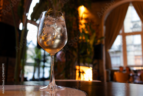 A glass of white wine on a table in a restaurant.