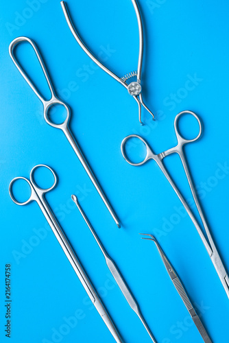 Картината върху платно A lot of stainless surgical instruments and tools on blue table, top view