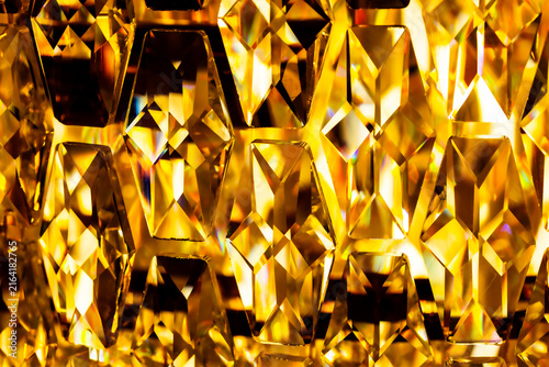 Macro close up of faceted golden crystal chandelier pattern texture background