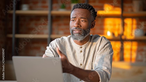 Confident man engaging in online video meeting with focus on communication and expression
