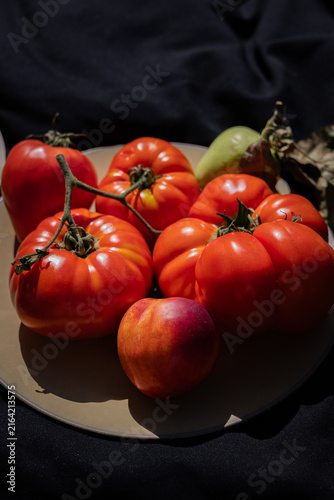 Ripe heirloom tomatoes with nectarine and green apple on plate