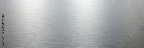 Brushed silver metal texture with horizontal grain, polished stainless steel background with light reflections, industrial metallic surface for sleek modern web design and product backdrops