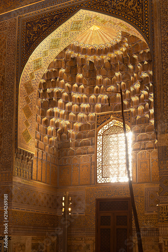 Foto Golden muqarnas vault inside Gur-e-Amir mausoleum in Samarkand with sunlight streaming through a lattice window