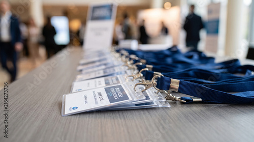 Conference badge lanyards on registration desk, corporate event name tags lined up, business seminar pass holders isolated on White Background