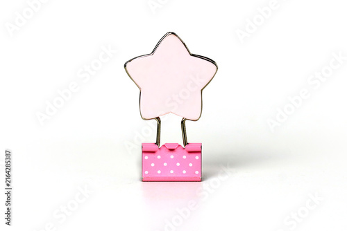 Cute pink star-shaped binder clip with white polka dots, isolated on a clean white background.