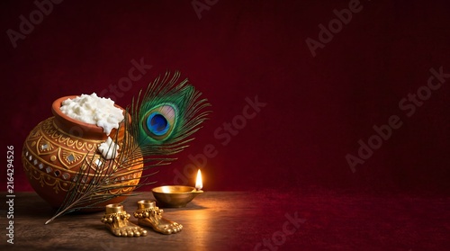 Krishna janmashtami celebration background with butter pot with ornaments beside glowing
