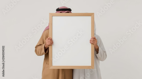 Arab couple holding blank picture frame
