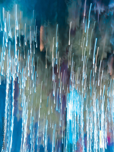 Abstract long exposure neon light trails creating a dynamic motion blur background with vertical glowing streaks.