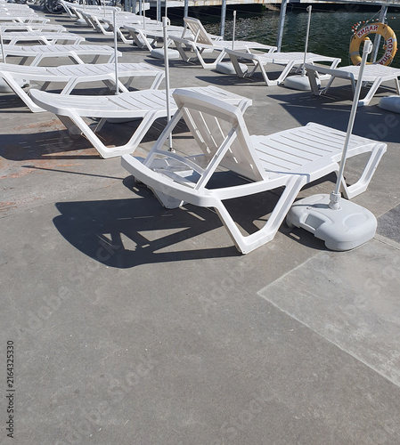 Cuadro en lienzo Empty White Sun Loungers on a Sunny Waterfront Deck