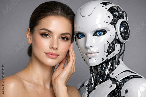 A woman posing next to a robotic head, highlighting the fusion of human and technology.