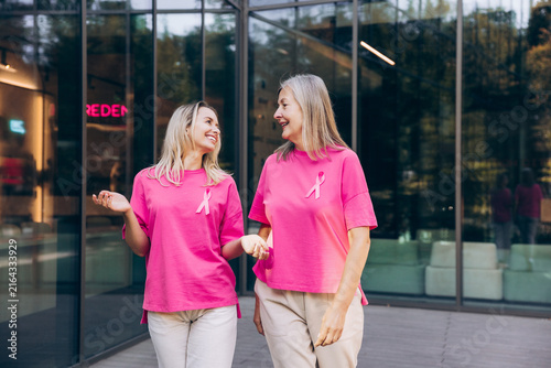 Bild auf Leinwand Portrait of two smiling happy women, senior and young wearing stylish pink t shi