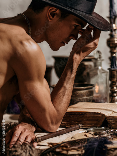 Man Adjusting Hat While Studying Antique Papers