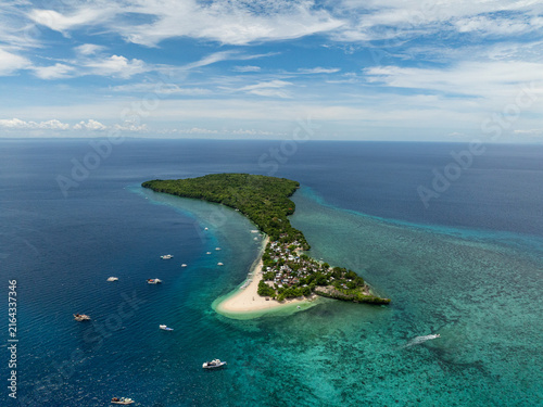 фотографія Tropical island with white sand beach, turquoise water, boats and green forest in the sea