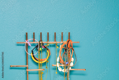 Obraz na płótnie Metallic jewelry organizer hanging on blue spruce wall