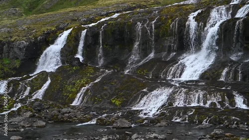 Aerial Drone View of Wide Multi-Tiered Waterfall Cascading on Mossy Basalt Cliffs in Iceland Westfjords