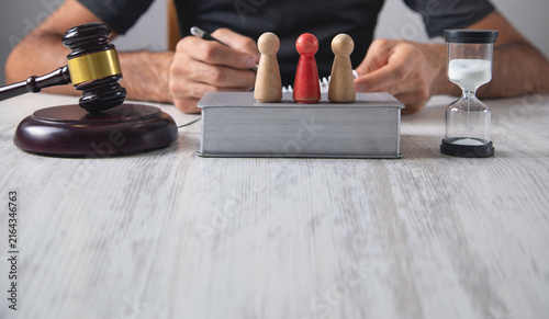 Fotografie Man with a judge gavel and wooden human figures.