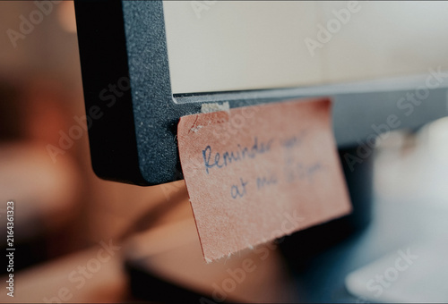 Sticky note reminder on a computer monitor