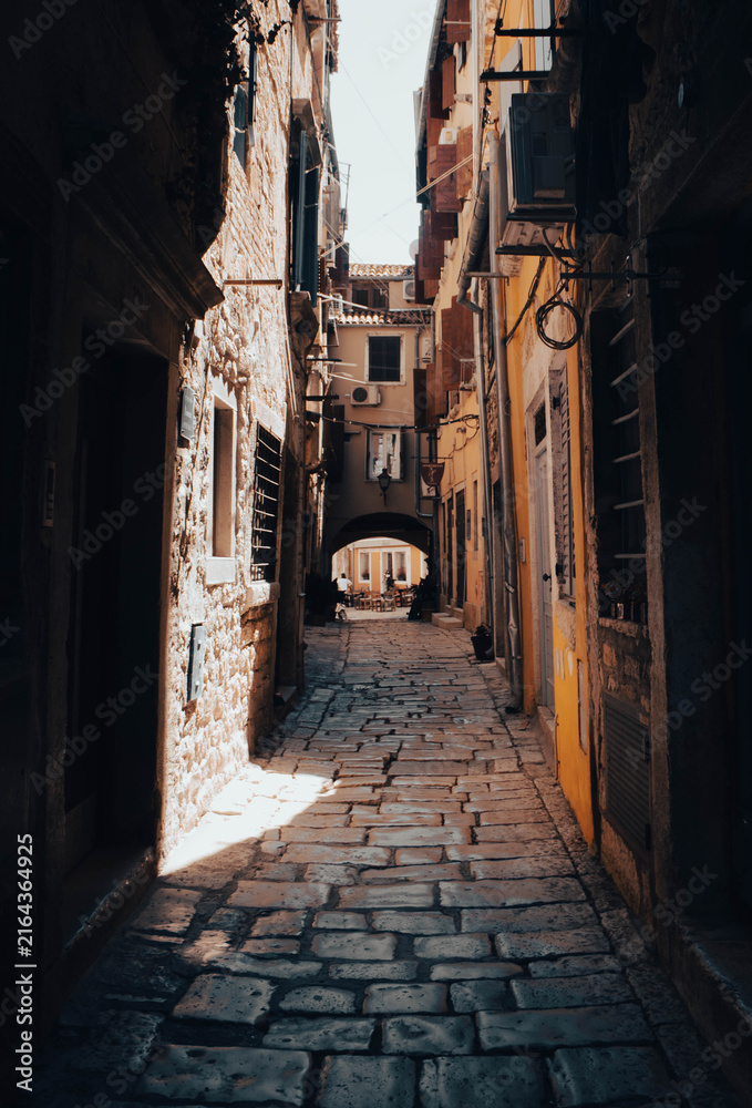 Fototapeta premium Narrow old street with cobblestone and historic buildings in a Mediterranean village