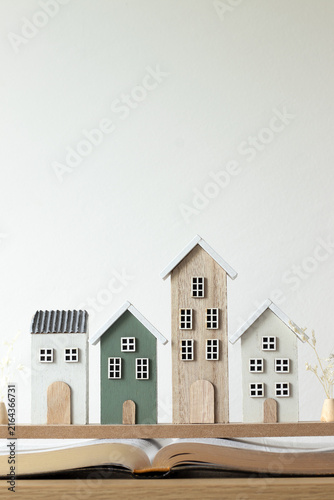 Miniature houses on top of holy bible book. Copy space. Christian concept of faith in God Jesus Christ, spiritual foundation, family, fellowship and community.