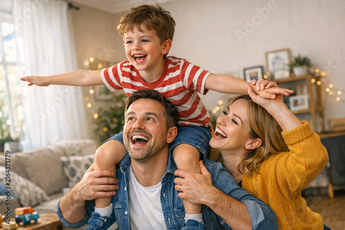 Family of three having a joyful time together at home during Christmas season.