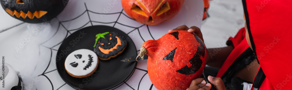 Naklejka premium Little boy enjoys Halloween with a colorful costume and fun decorations