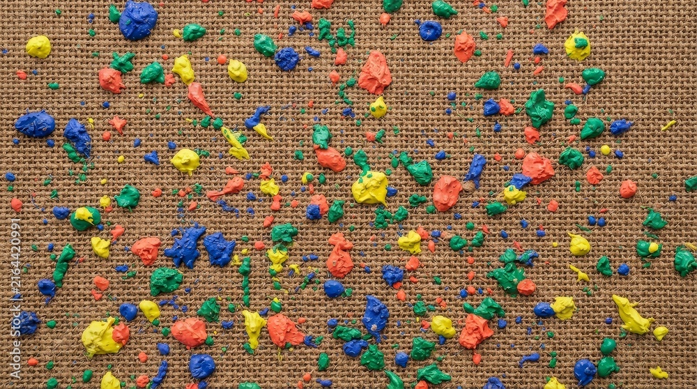 Obraz premium Colorful paint splatters on textured brown surface