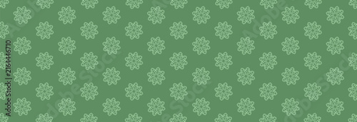 Elegant winter Christmas and New Year seamless pattern with snowflakes in a mandala shape on a solid green background. This minimalistic Christmas geometric texture is perfect for holiday wrapping pap