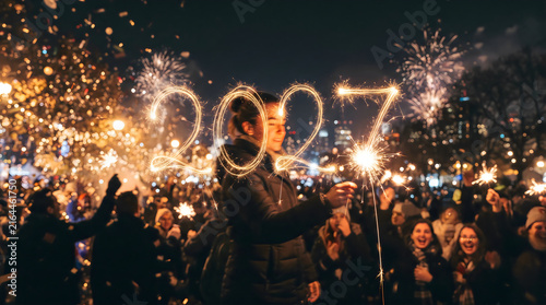 Happy New Year 2027 Sparkler Light Painting Celebration with Fireworks and Crowd