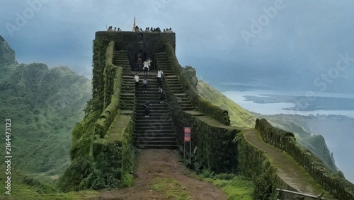 Canvastavla Trekkers climbing the steep stone staircase of an ancient hill fort bastion overlooking a lush valley and lake in the Western Ghats, Maharashtra