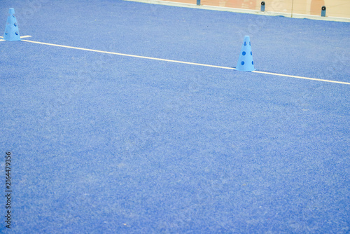 High angle view of a blue agility marker cone used for tennis and padel drills on turf floor
