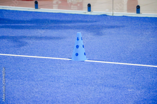 High angle view of a blue agility marker cone used for tennis and padel drills on turf floor