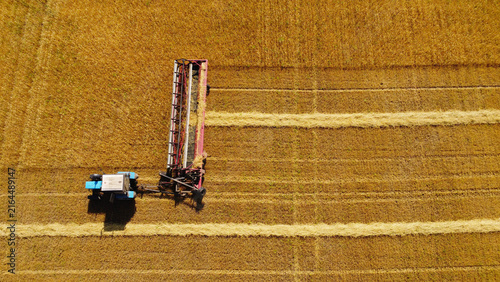 Картината върху платно Aerial Top-Down View of Tractor with Swather Cutting Golden Crop Field