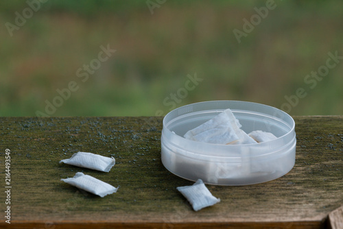 Canvastavla nicotine pouches white snus container on old wooden board with natural green bac
