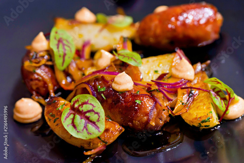 Konstfotografi Gourmet sausage and potato dish with microgreens and sauce.