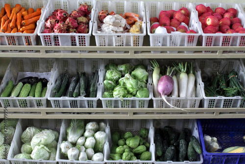 Fresh Market Vegetables on Shelves in Plastic Crates at Grocery Produce Display