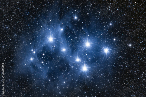 Mesmerizing deep space photograph of the iconic Pleiades star cluster, M45, also known as the Seven Sisters, featuring brilliant hot blue stars illuminating intricate, wispy reflection
