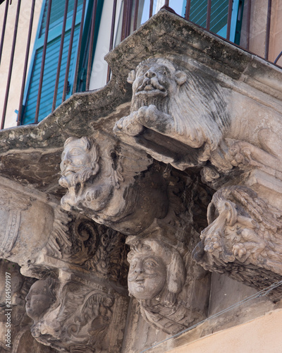 Cuadro en lienzo Modica, Italy; 1st August 2026: Baroque architectural detail with carved grotesque face and ornate stonework on a balcony in Sicily