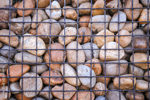 Obraz na plátně gabion wall (also known as a bronjong), which is a structure made of natural river stones or pebbles held inside a sturdy metal wire mesh cage