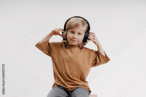 portrait of cute 4-5 year old boy with headphones on his head on white background